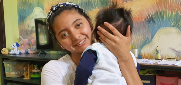 Coralia holding an abandoned baby at the Vida Children's Home